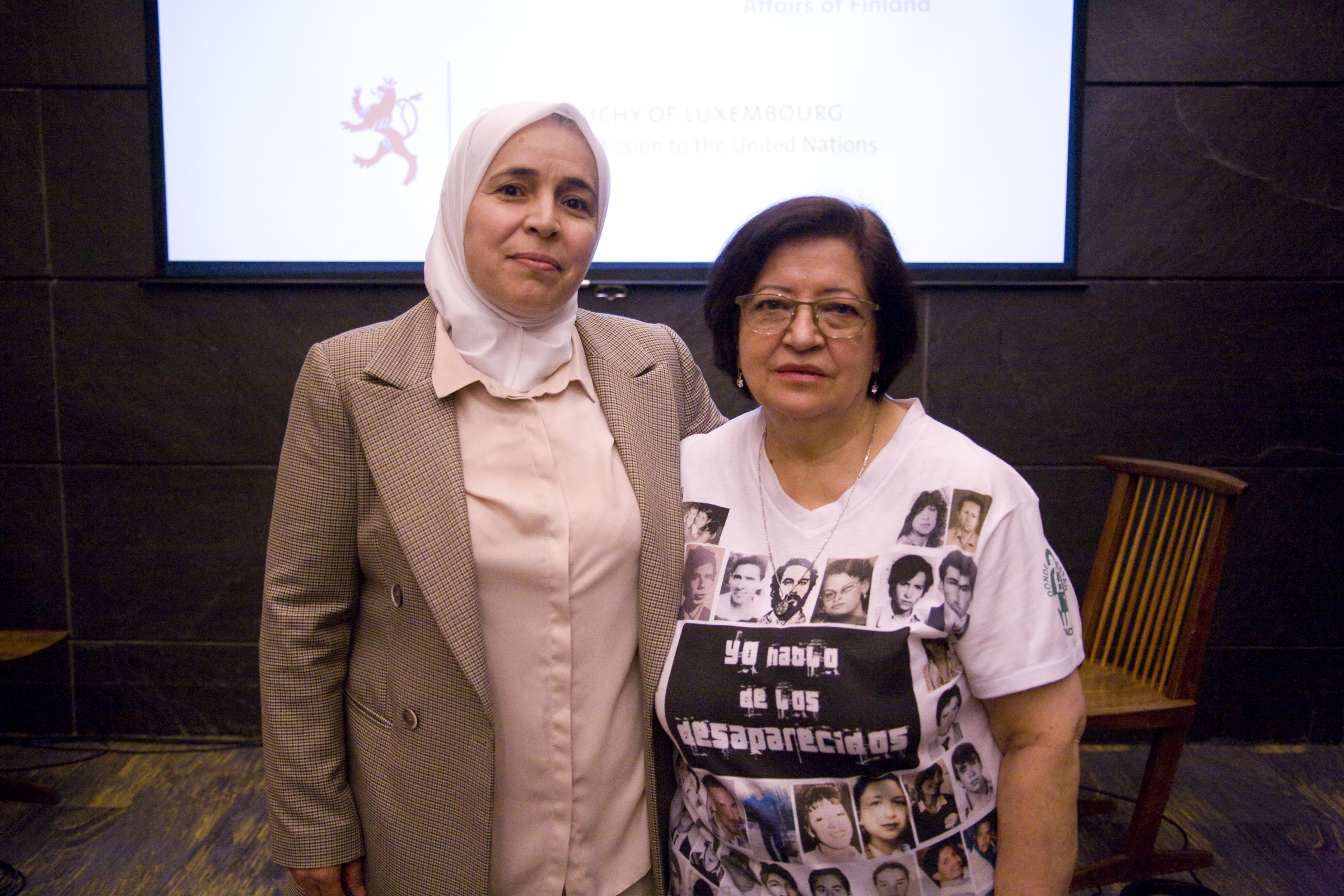 Dos mujeres de pie, una al lado de la otra, posan para una fotografía.