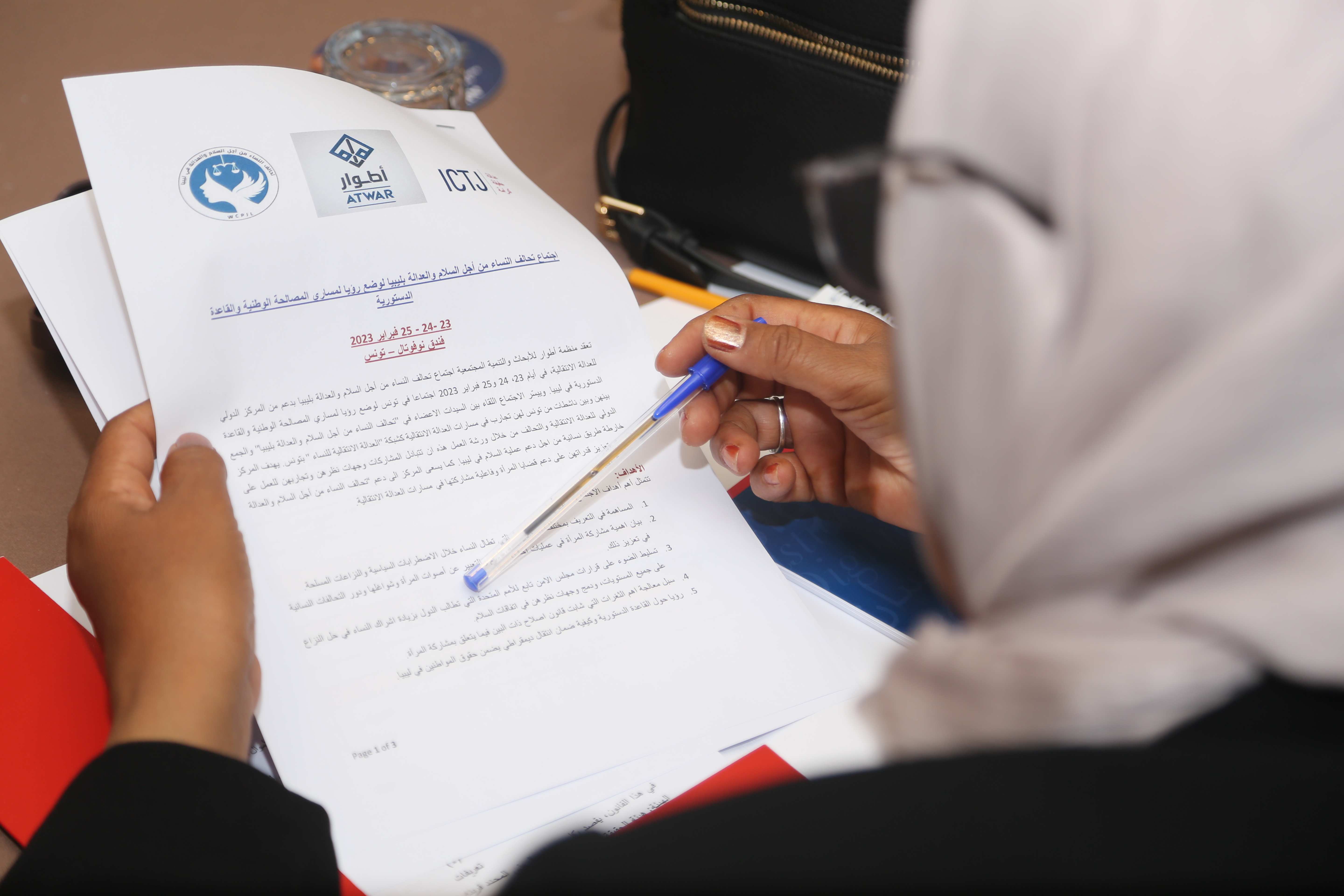 A Libyan participant reads over the program and concept note for the February 2023 workshop in Tunis. 