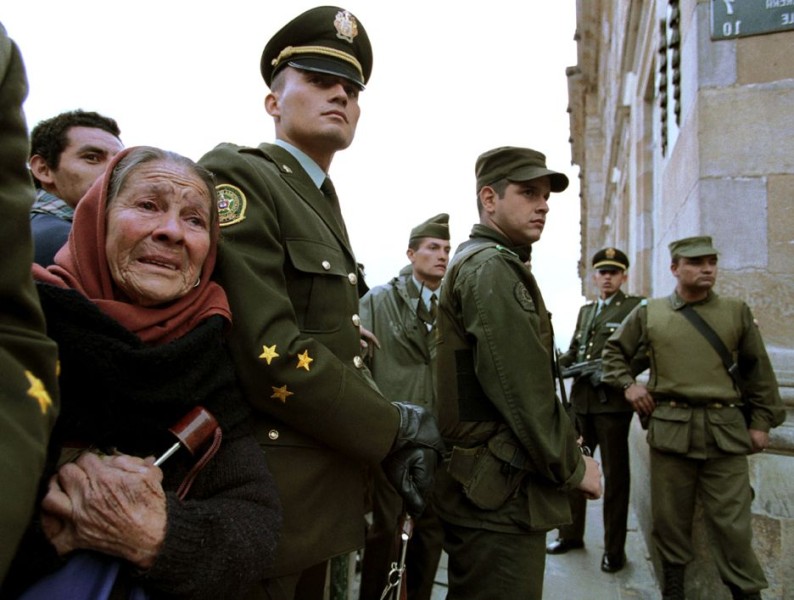 Image of an elderly lady mourning at the funeral of an assassinated public figure in Bogota.