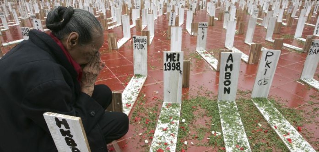 Image of a woman carrying among 1,000 "tombs" during a protest in Jakarta.