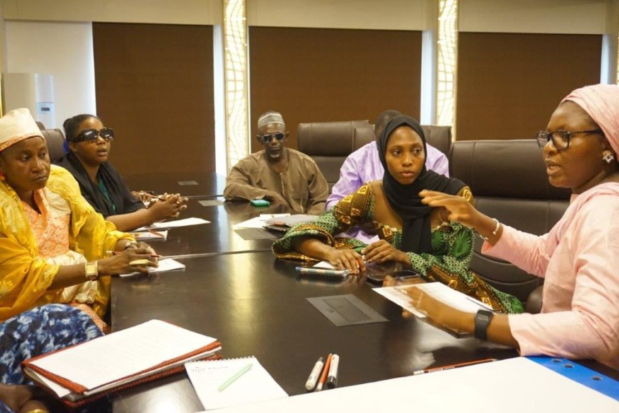 People sit around a conference table and engage in a discussion.