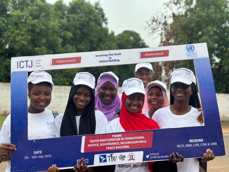 Seven young Gambian women smile for a photo