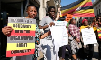 People protest in the street holding signs.