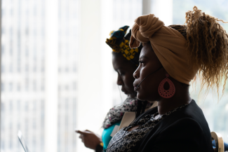 Two women seated indoors look intently ahead of them.